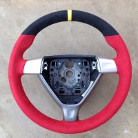 997,987 (traingular airbag) - thicker, thumb grips built up, red Alcantara, black top section + yellow centre stripe at 12 o'clock